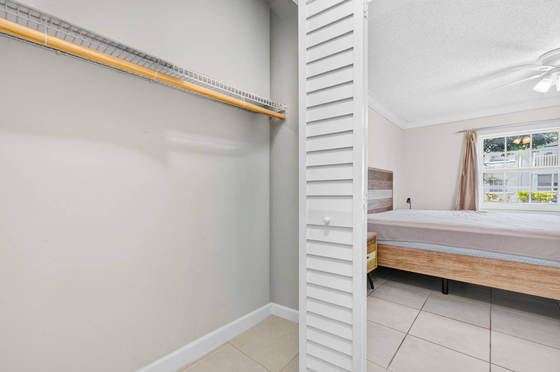 6359 Bay Club Drive, #2, Fort Lauderdale, FL 33308 Spacious walk-in closet with dual hanging rods, louvered storage door, and tile flooring