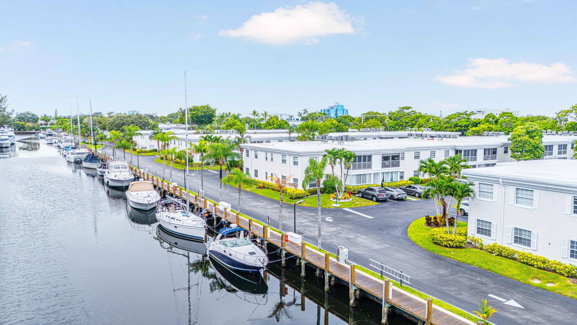 6359 Bay Club Drive, #2, Fort Lauderdale, FL 33308 Waterfront property featuring a private dock, tropical landscaping, and a paved parking area