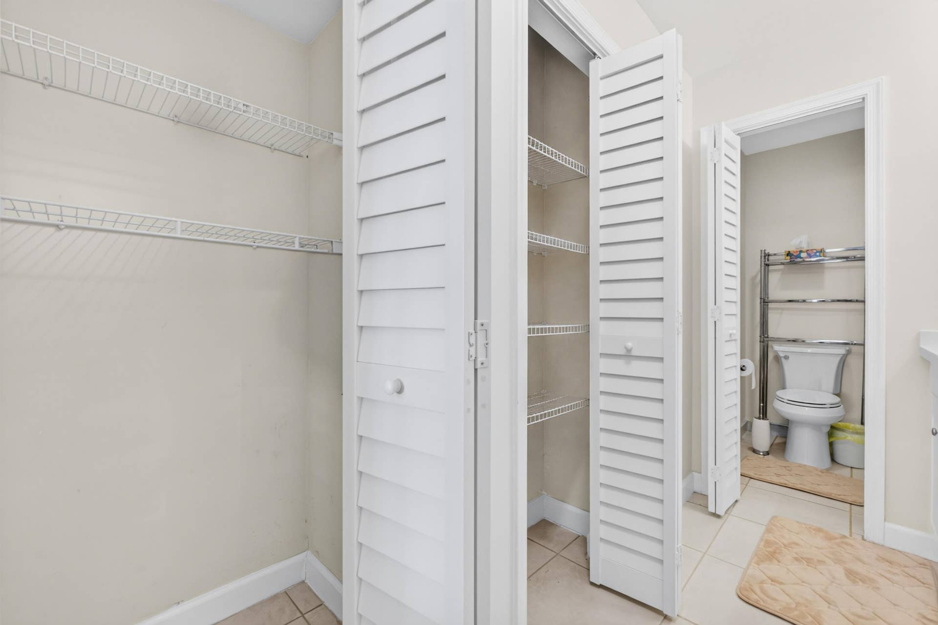 6359 Bay Club Drive, #2, Fort Lauderdale, FL 33308 Spacious walk-in closet with louvered double doors, multiple shelving units, and abundant storage capacity