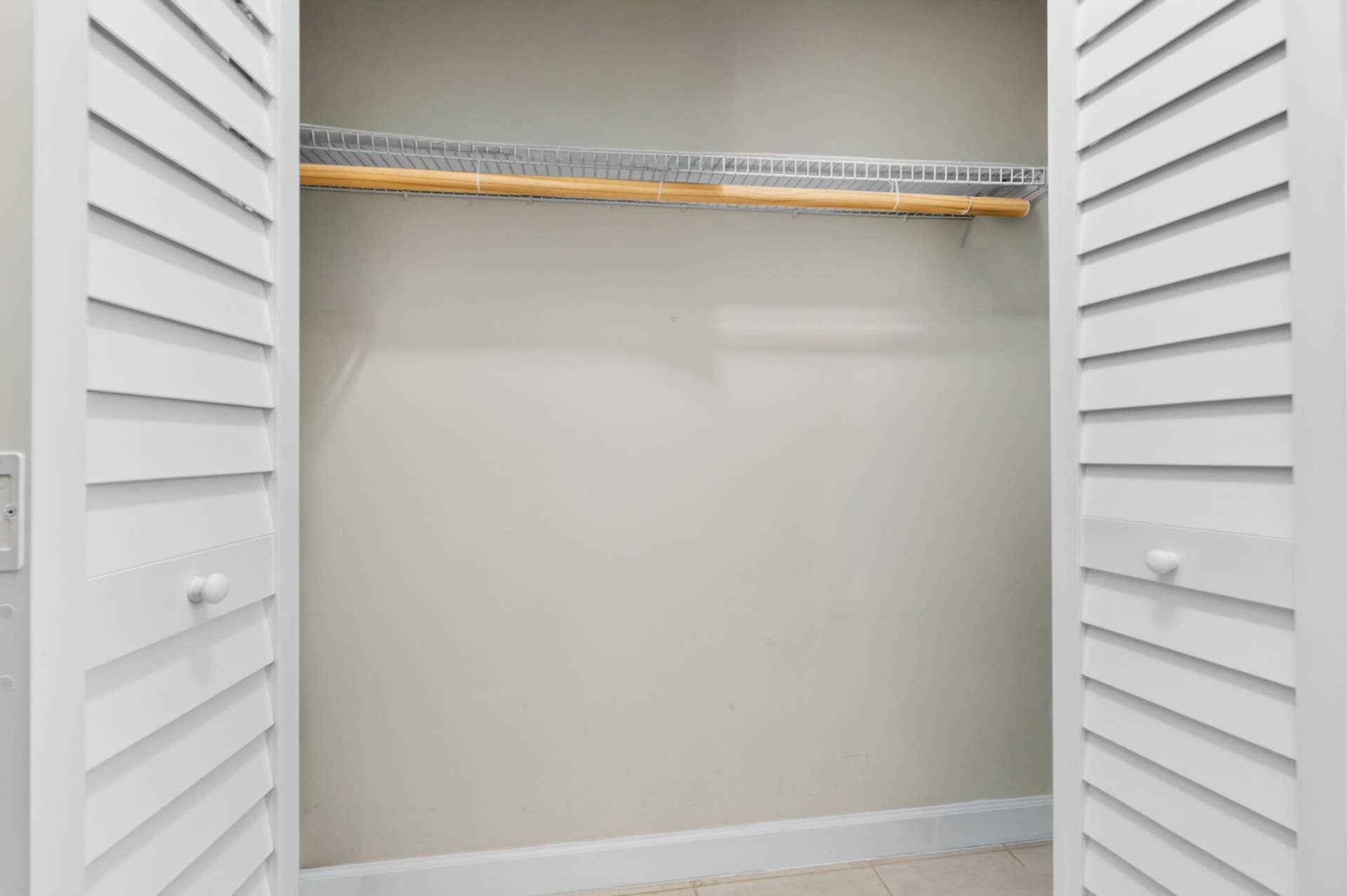 6359 Bay Club Drive, #2, Fort Lauderdale, FL 33308 Louvered bi-fold doors opening to a built-in closet system with a wood hanging rod and wire shelving