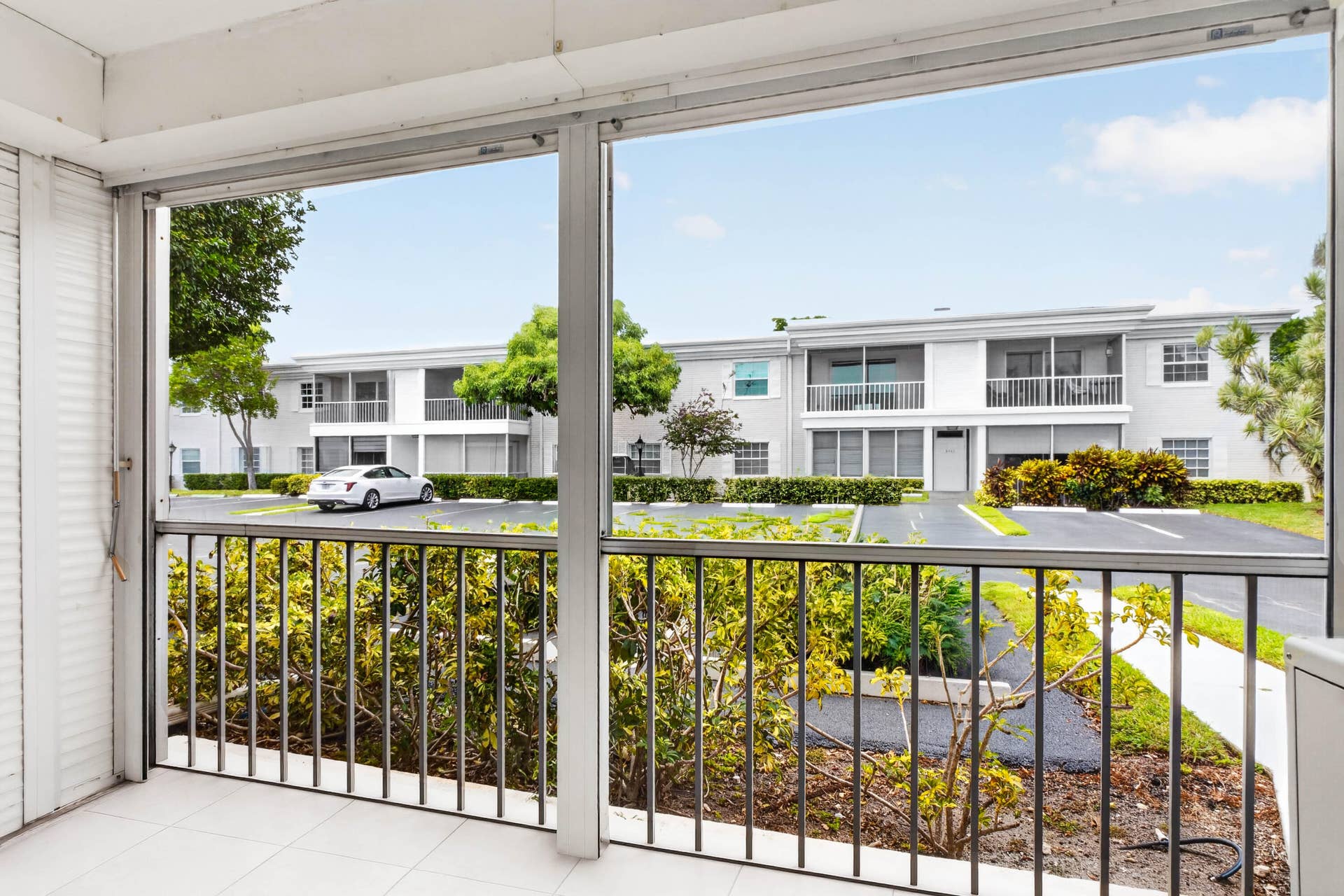 6359 Bay Club Drive, #2, Fort Lauderdale, FL 33308 Screened balcony with white tile flooring and metal railings