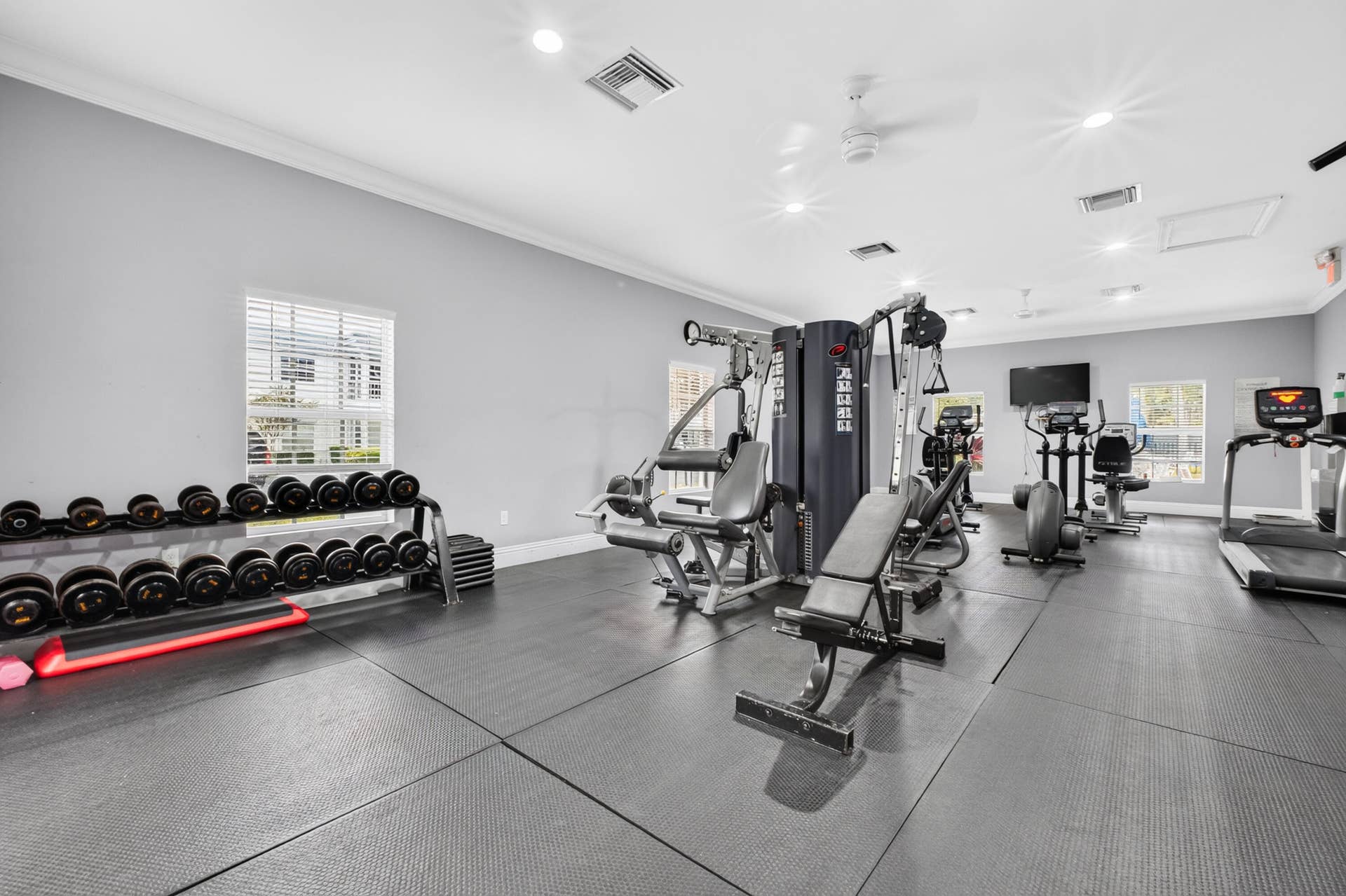 6359 Bay Club Drive, #2, Fort Lauderdale, FL 33308 State-of-the-art fitness facility featuring multiple strength training machines, comprehensive dumbbell rack system, rubberized flooring throughout, and abundant natural lighting from large windows