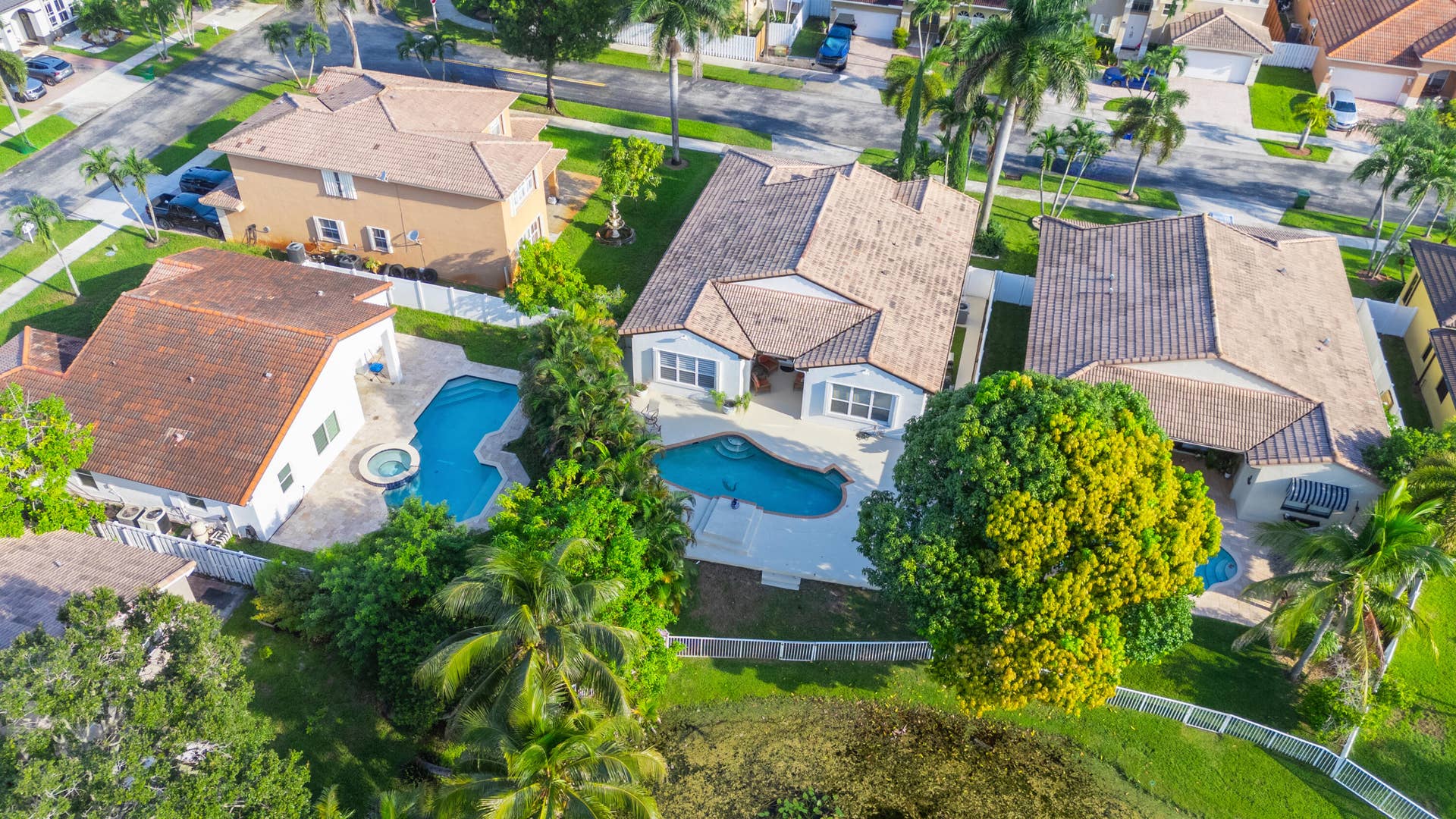 Aerial perspective showcases the homes backyard layout with private pool and water just beyond the property.