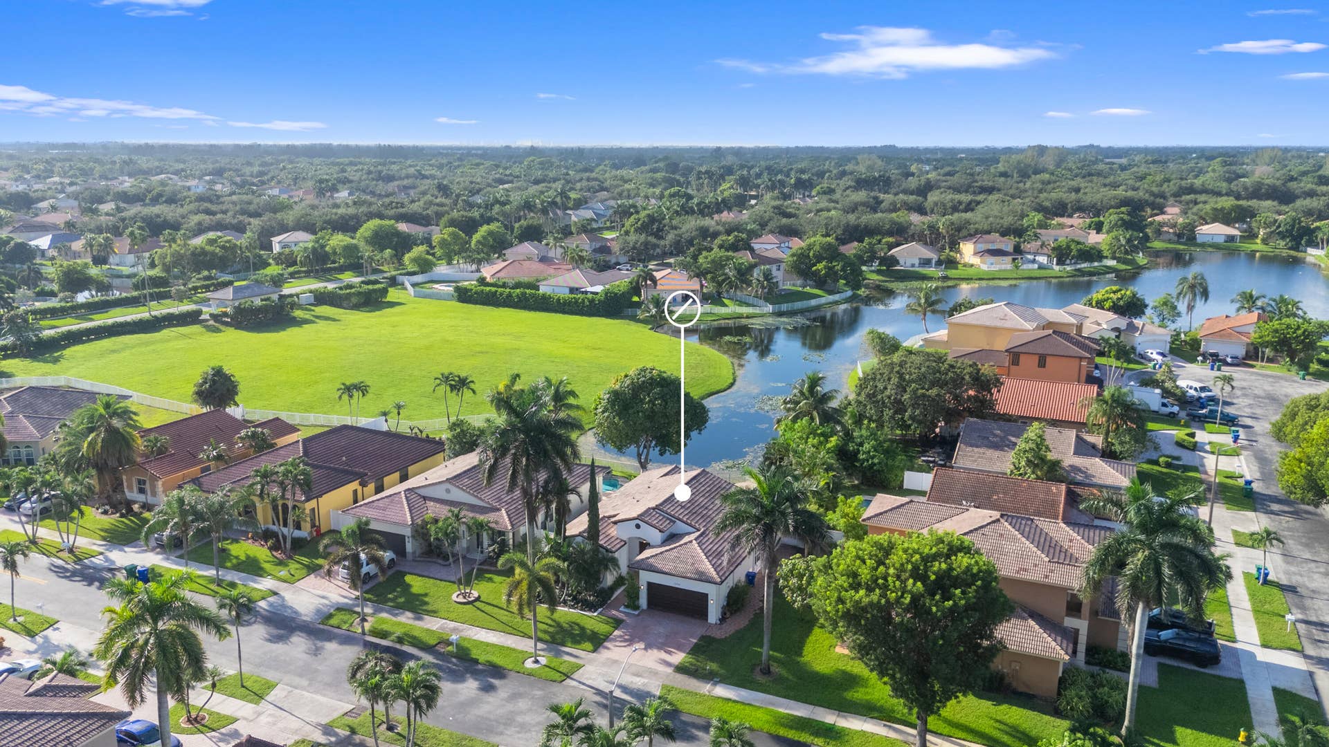 Elevated aerial view places the home within its residential surroundings and highlights the nearby waterway.