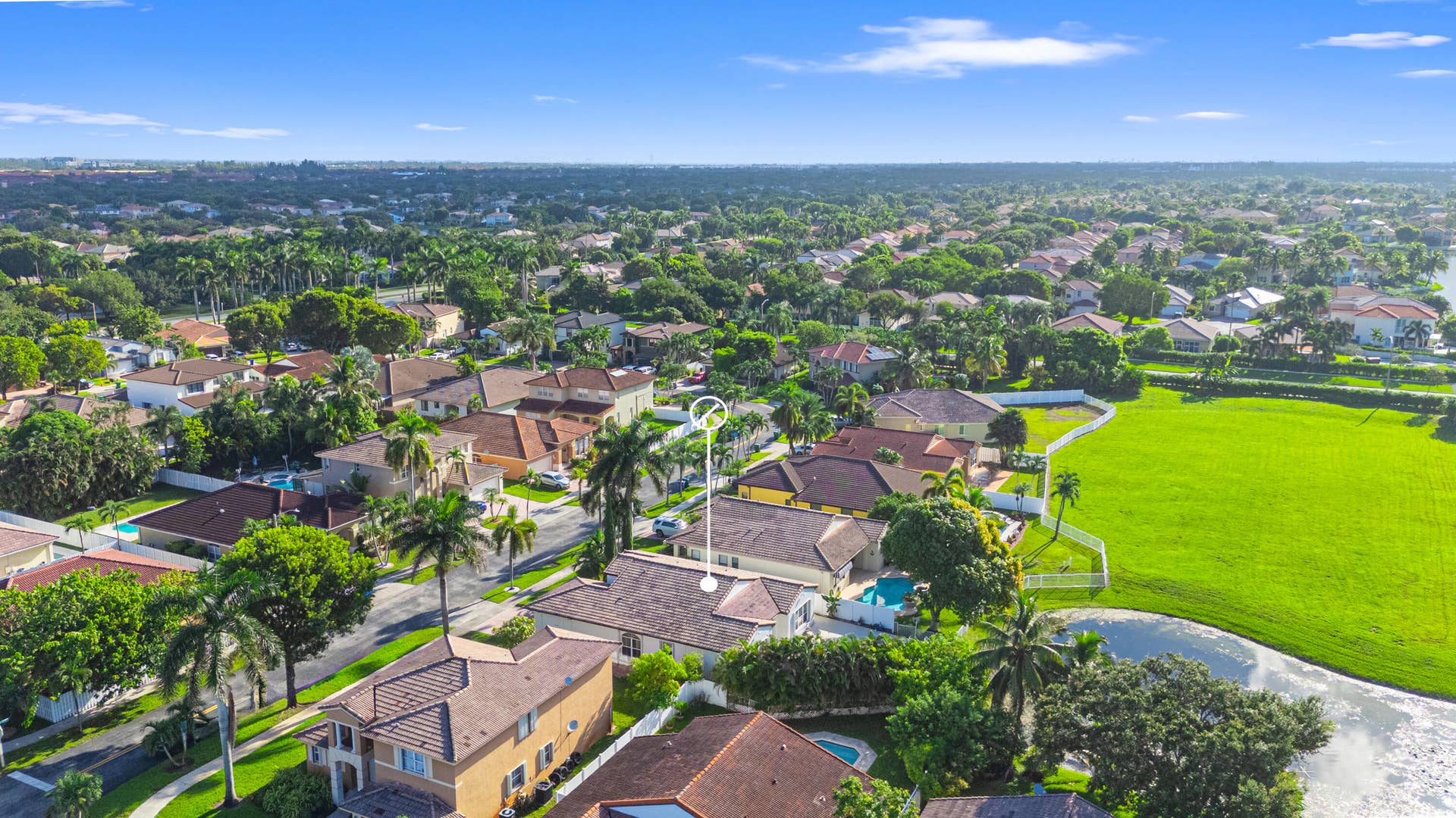 Aerial view provides additional perspective on the homes setting among neighboring residences and preserve.