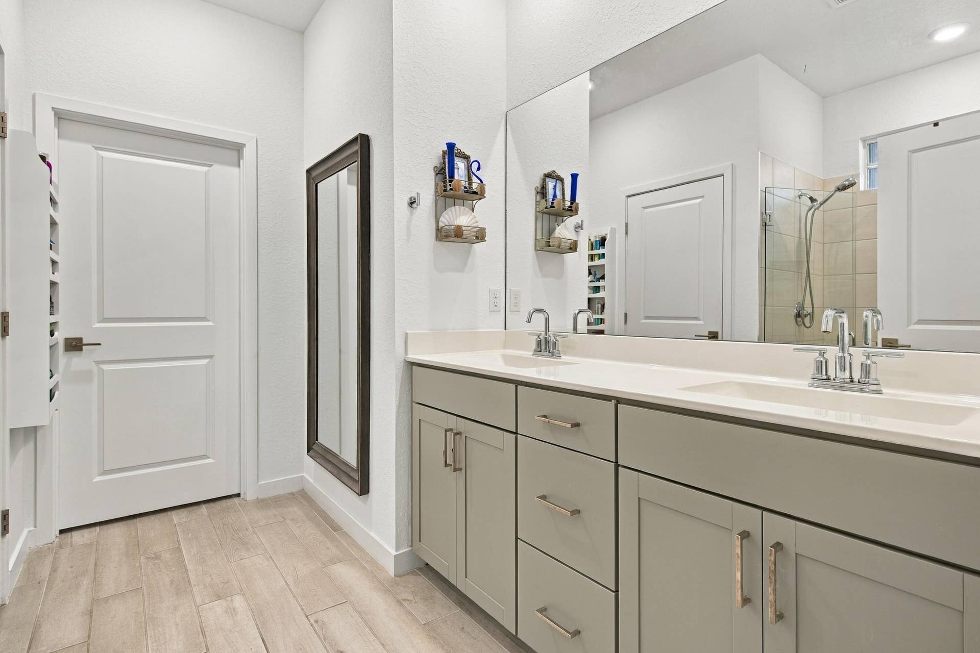 Primary bathroom with luxury wood like tiles, recessed lights, double sinks with draws