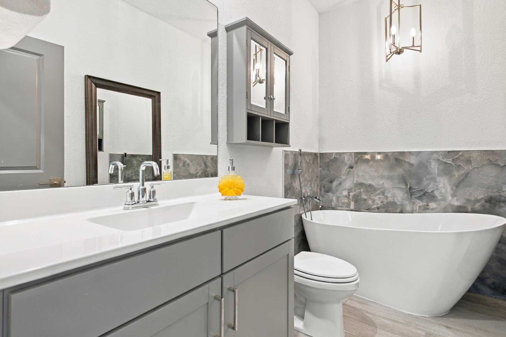 Large bathroom with porcelian soaking tub, recessed lights and newer light fixtures.