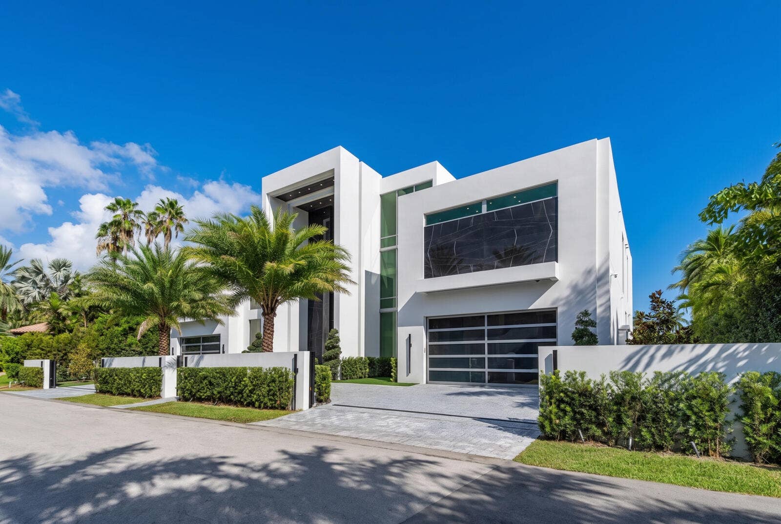 414 ROYAL PLAZA Drive, Fort Lauderdale, FL 33301 Right-side exterior view showcasing bold contemporary architecture, dramatic floor-to-ceiling glass, a sleek garage, private motor court, and lush tropical landscaping.