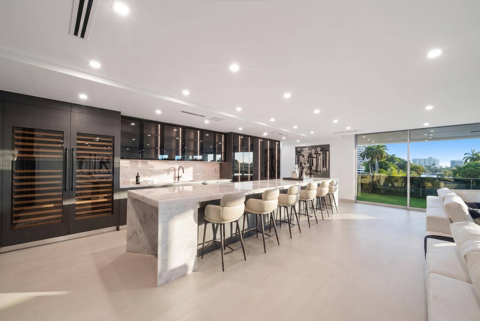 414 ROYAL PLAZA Drive, Fort Lauderdale, FL 33301 Showpiece 20-foot illuminated onyx bar featuring generous seating, custom smoked-glass cabinetry, dual wine storage, and sweeping skyline views.