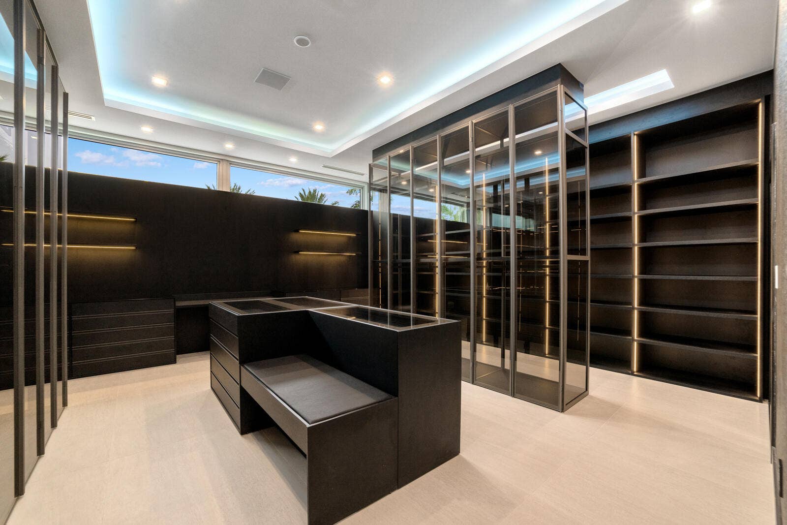 414 ROYAL PLAZA Drive, Fort Lauderdale, FL 33301 Extraordinary glass-enclosed boutique wardrobe with illuminated cabinetry, custom display cases, extensive storage, and a central dressing island with built-in seating