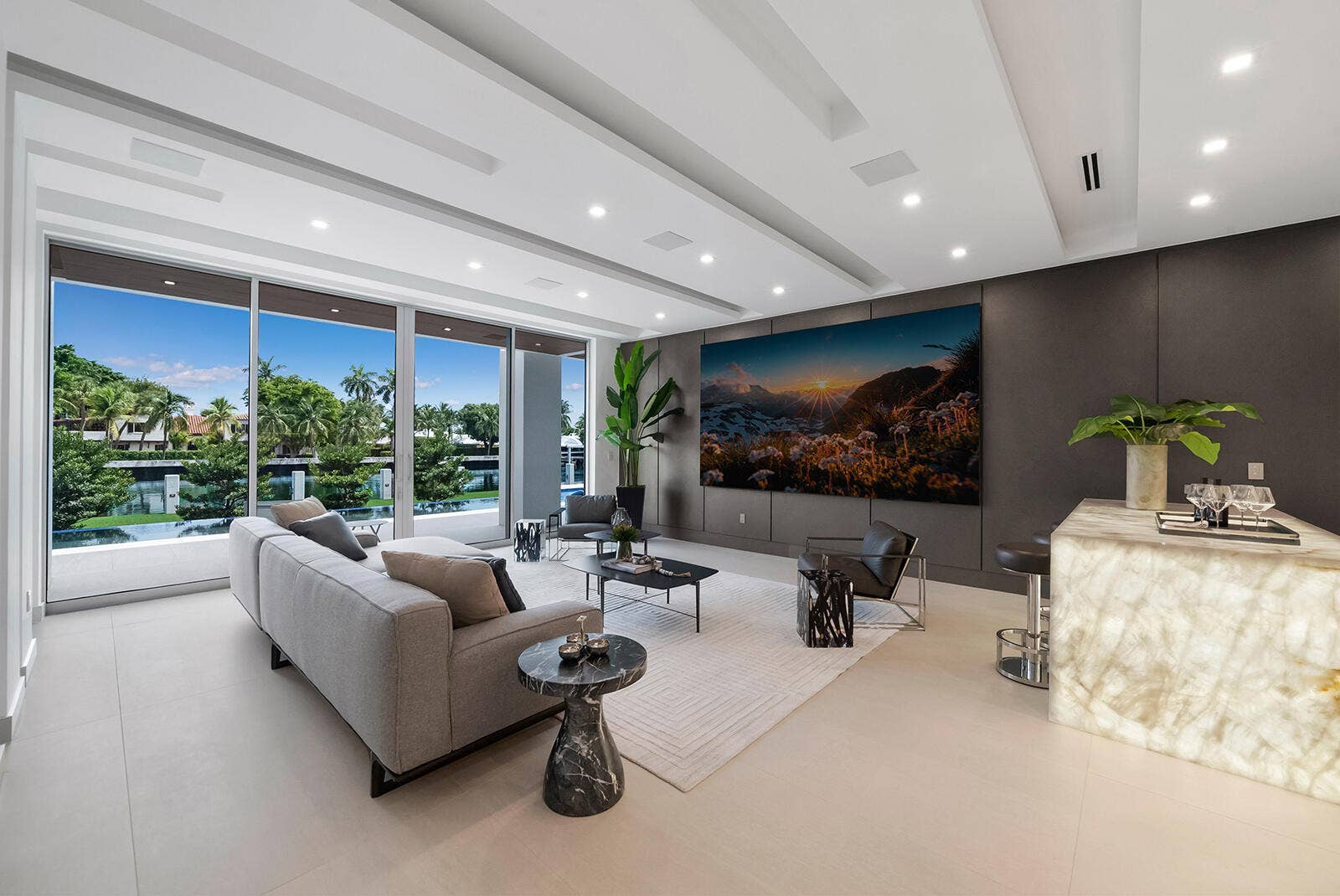 414 ROYAL PLAZA Drive, Fort Lauderdale, FL 33301 Expansive VIP lounge with floor-to-ceiling glass, serene waterfront views, custom wall paneling, oversized television, and direct access to the outdoor living area.
