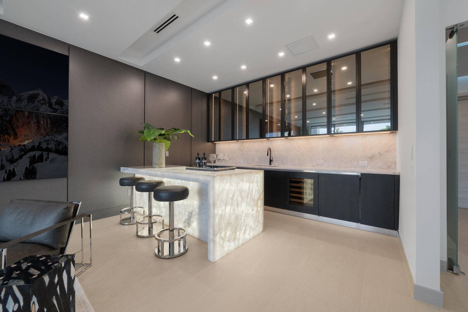 414 ROYAL PLAZA Drive, Fort Lauderdale, FL 33301 VIP suites full private bar showcasing a luminous waterfall-edge stone counter, seating for three, sink, wine refrigeration, illuminated backsplash, and smoked-glass cabinetry.