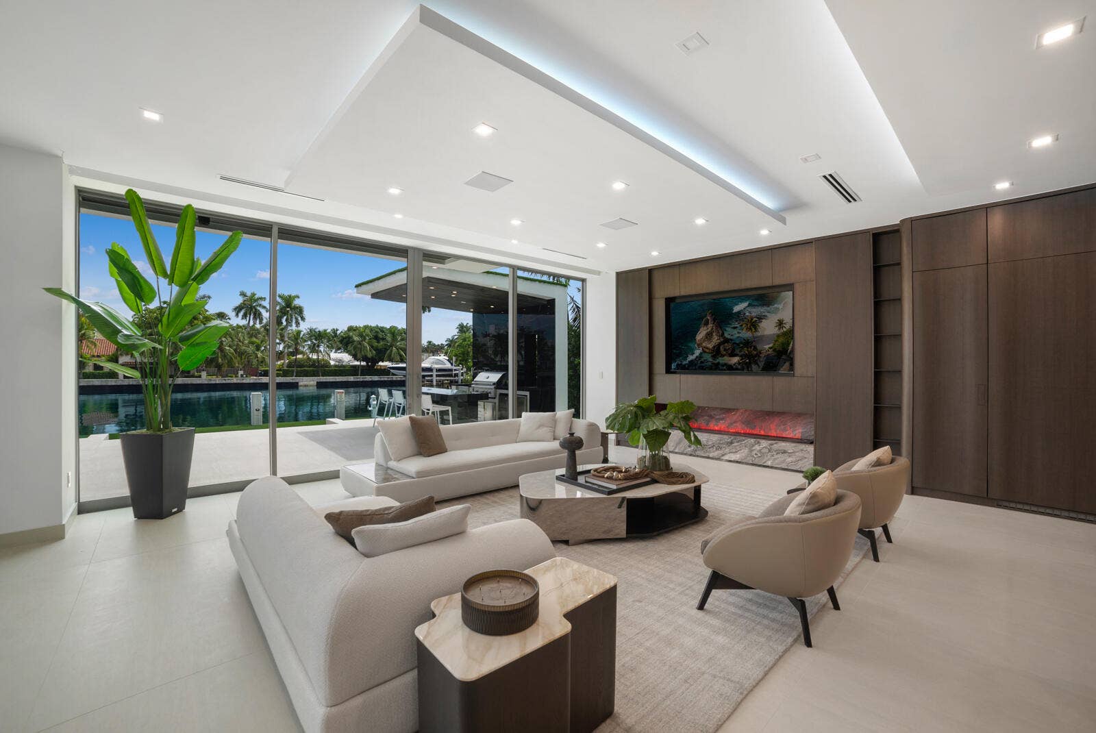 414 ROYAL PLAZA Drive, Fort Lauderdale, FL 33301 Sophisticated family room positioned beside the showpiece kitchen and separate butlers kitchen, offering custom cabinetry, a linear fireplace, architectural lighting, and seamless indoor-outdoor waterfront living.