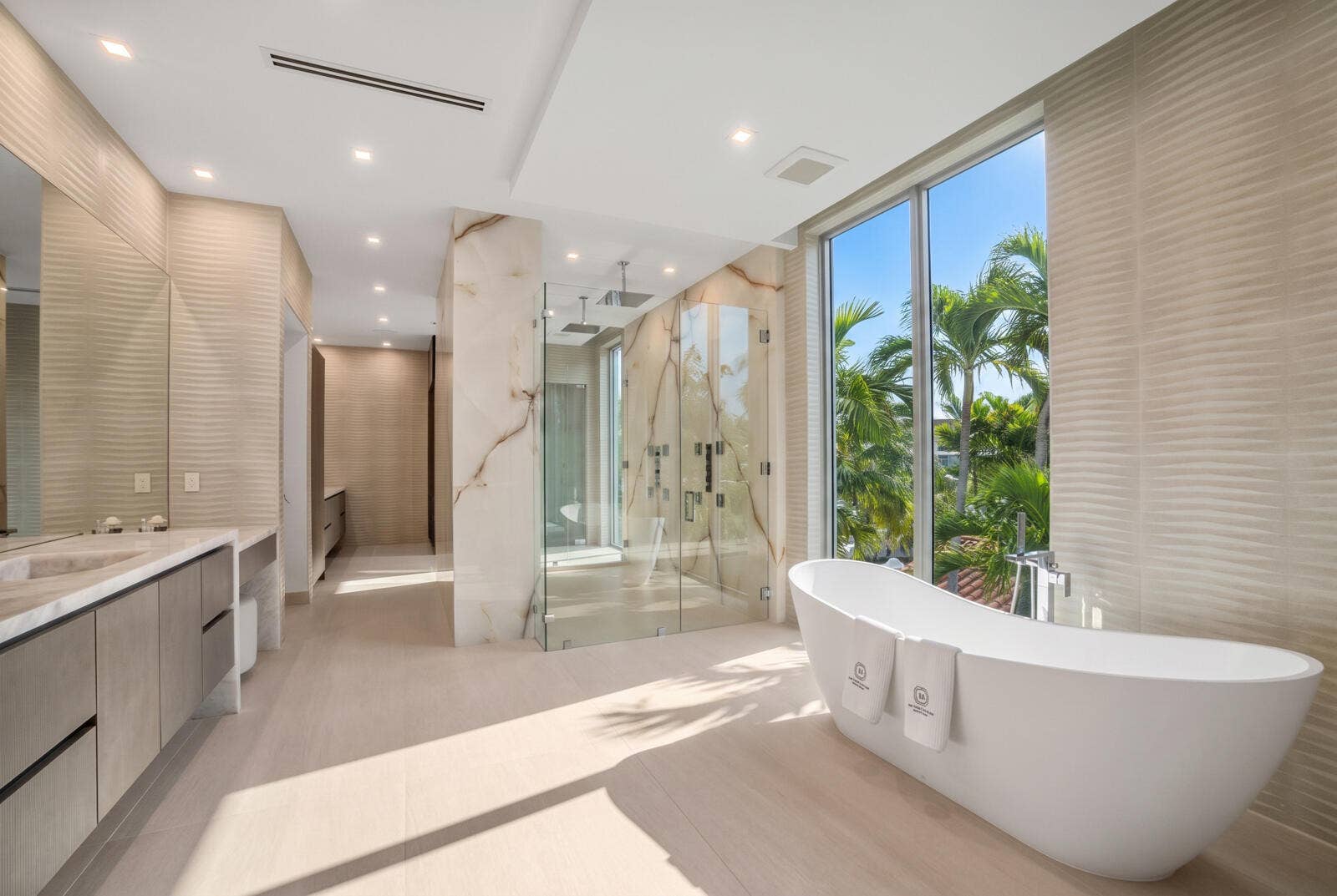 414 ROYAL PLAZA Drive, Fort Lauderdale, FL 33301 Spa-inspired primary bathroom with a sculptural freestanding tub, expansive windows, dual vanities, and an oversized glass shower wrapped in book-matched stone.