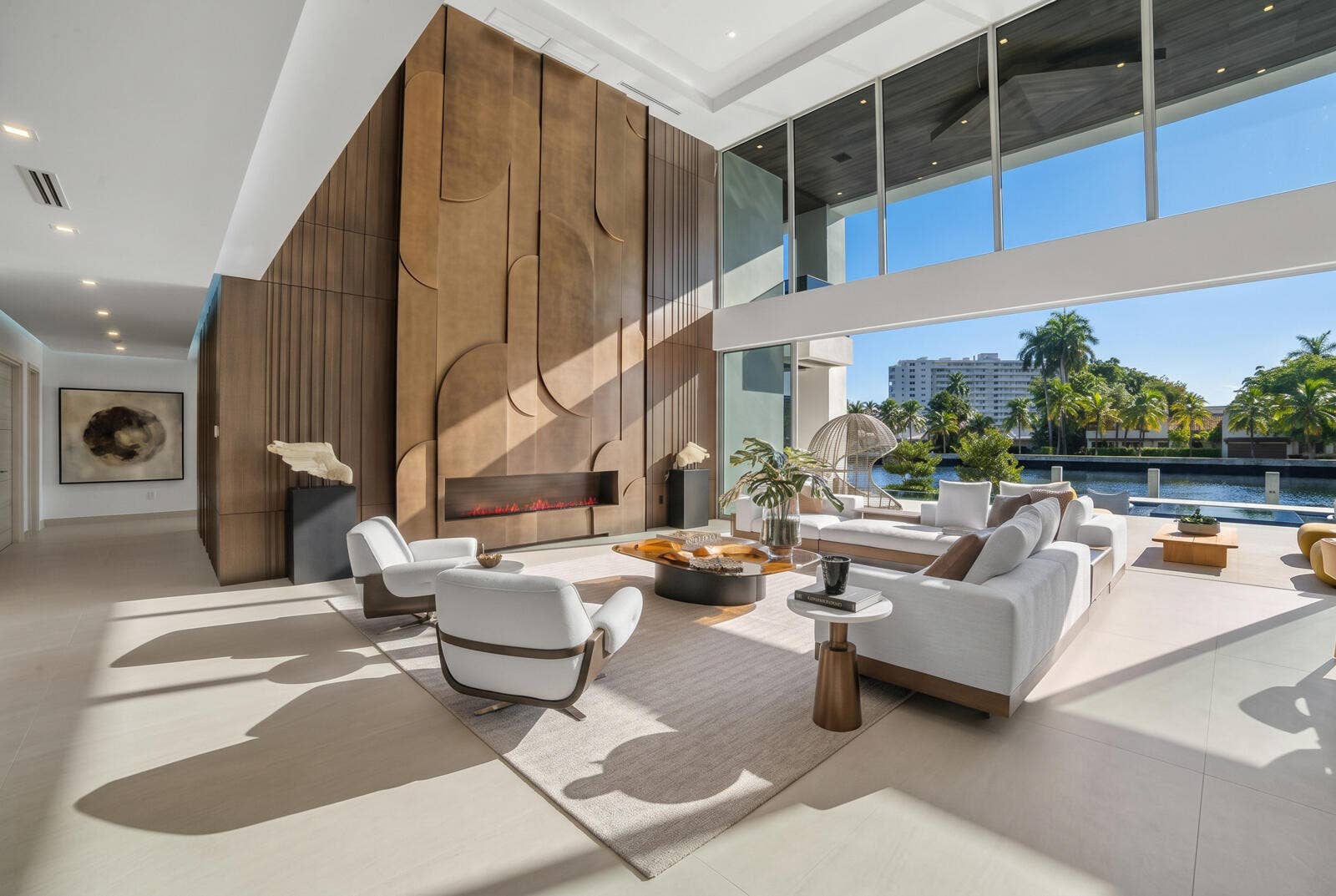 414 ROYAL PLAZA Drive, Fort Lauderdale, FL 33301 Soaring two-story great room framed by floor-to-ceiling glass, a dramatic paneled feature wall, linear fireplace, and captivating waterfront views.
