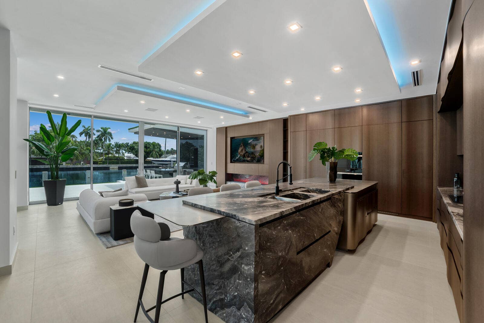414 ROYAL PLAZA Drive, Fort Lauderdale, FL 33301 Open-concept kitchen and family room featuring a waterfall-edge natural-stone island, custom Italian cabinetry, architectural cove lighting, and uninterrupted waterfront views.