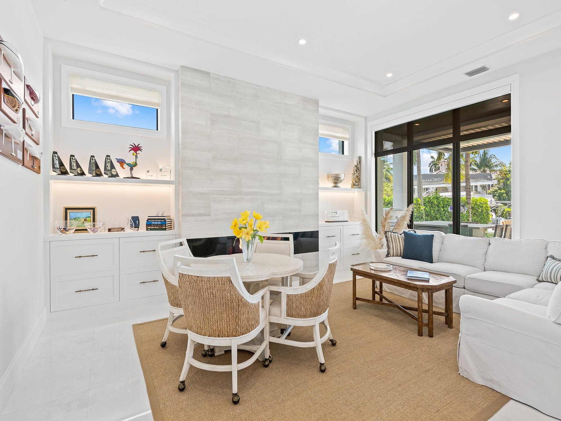 301 NE 23RD Avenue, Fort Lauderdale, FL 33305 Stunning custom built-in bookshelves frame a sophisticated fireplace, creating a warm and elegant focal point in the living space