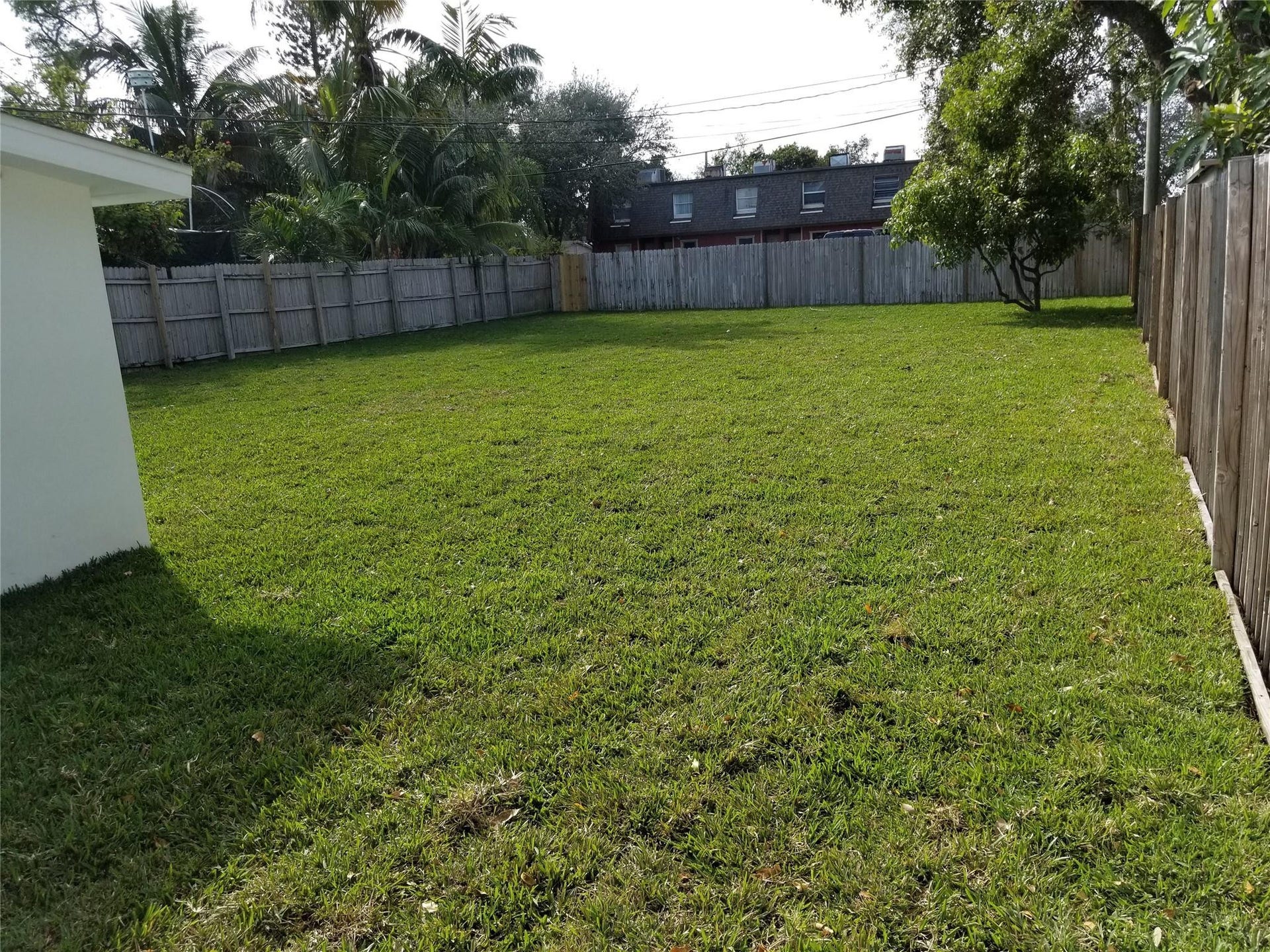 Expansive grass lawn with perimeter wood fencing
