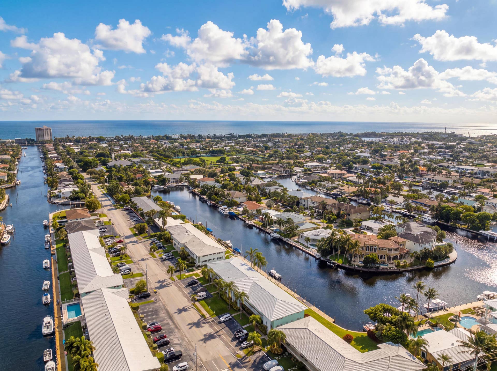 2330 NE 36th Street, #11, Lighthouse Point, FL 33064 Waterfront community featuring multiple canals with boat access, residential properties with private docks, a distant ocean horizon, and abundant mature trees