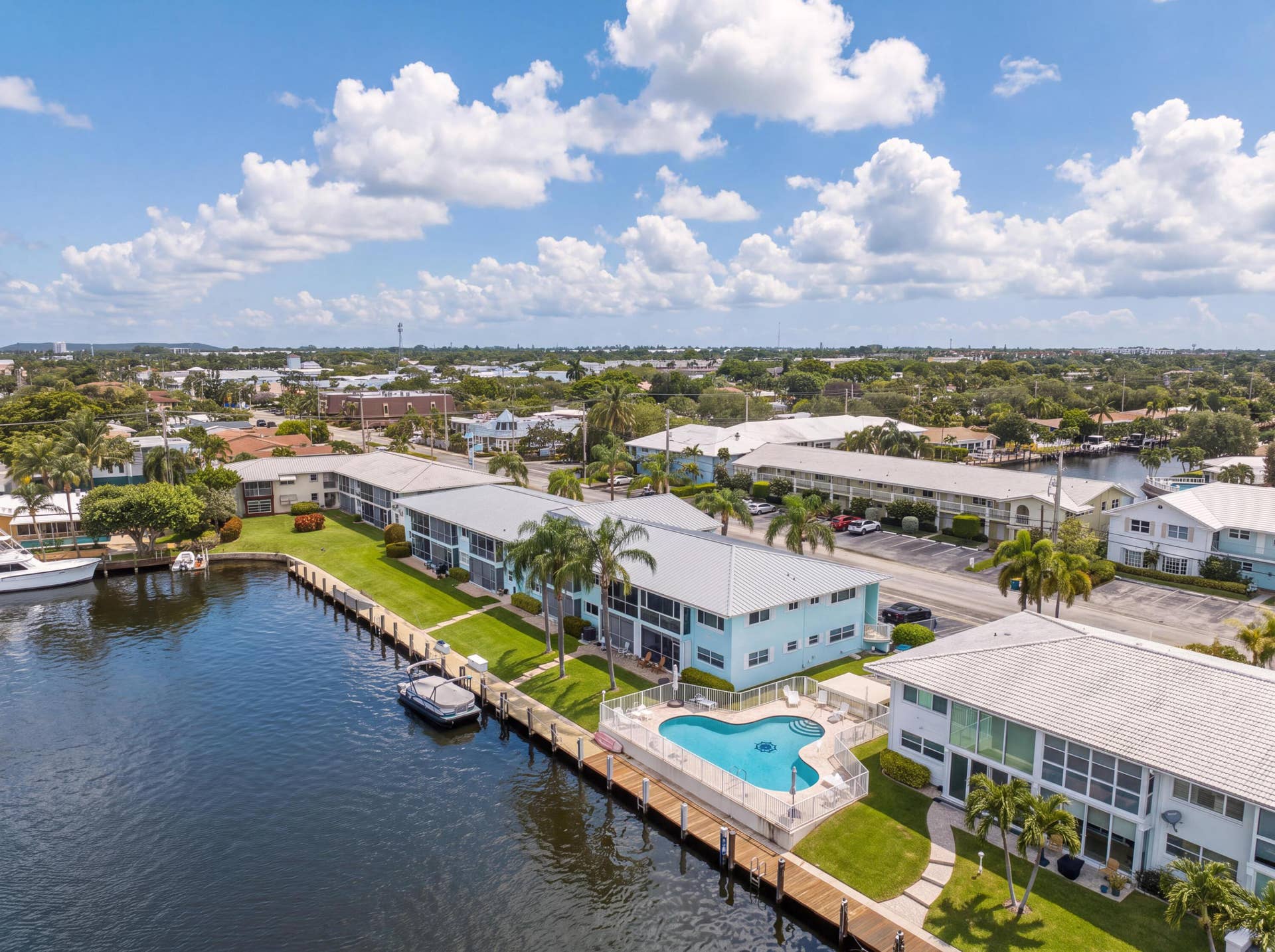 2330 NE 36th Street, #11, Lighthouse Point, FL 33064 Waterfront property with private boat docks, a swimming pool, and mature palm trees
