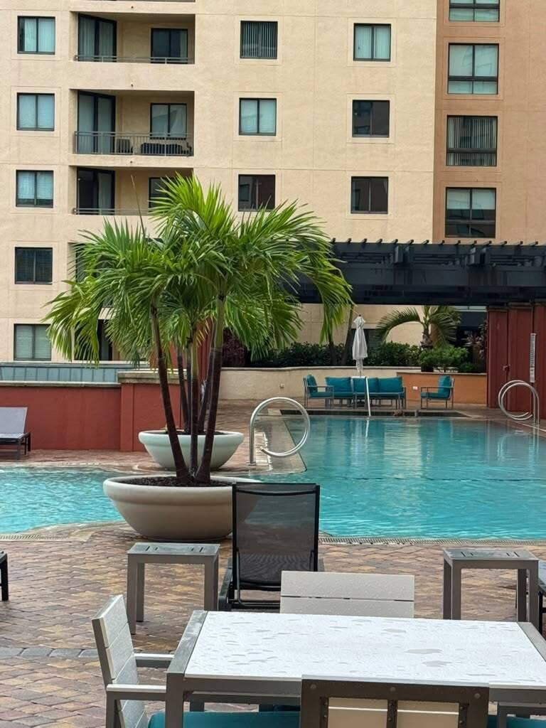 Resort-style pool with integrated seating, surrounded by a paved patio