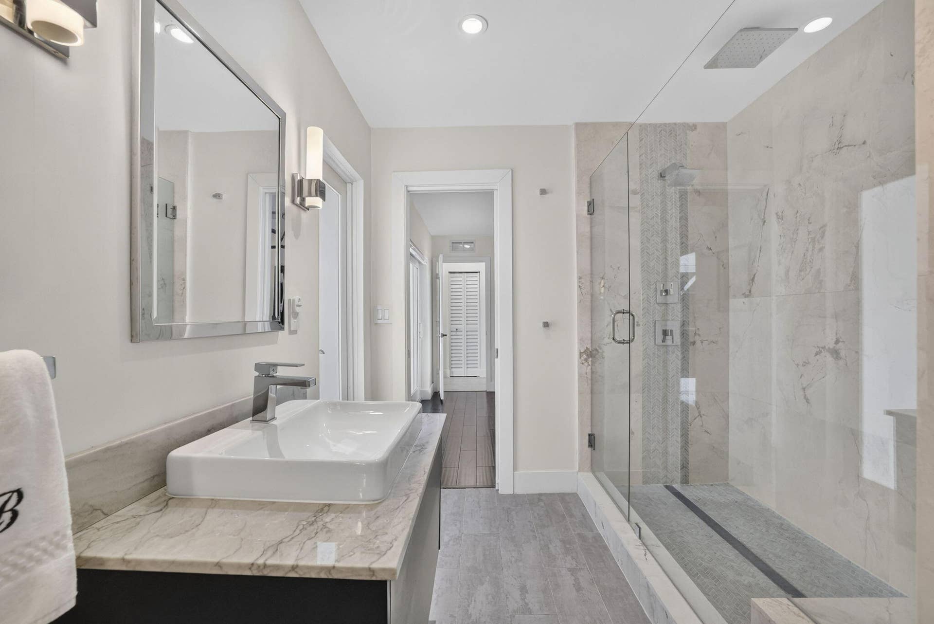 Floating vanity with a vessel sink, polished chrome faucet, and rectangular mirror