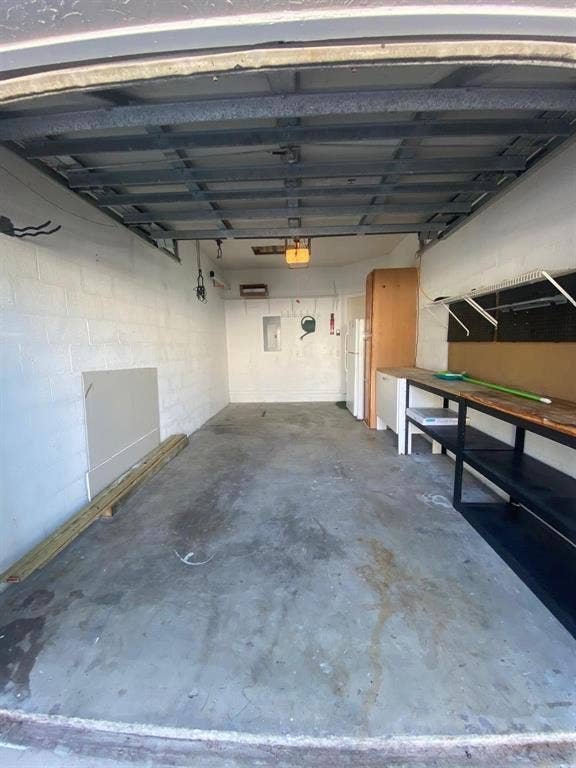 791 NW 42ND Place, Deerfield Beach, Deerfield Beach, FL 33064 One car garage with concrete flooring, overhead lighting, and built-in shelving