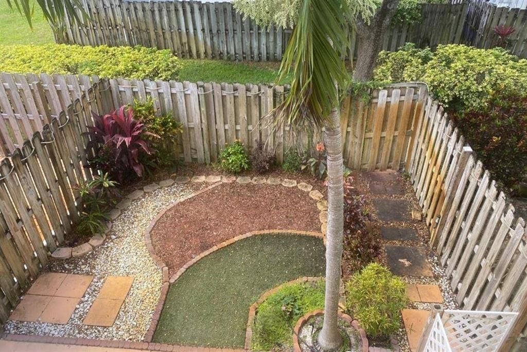 791 NW 42ND Place, Deerfield Beach, Deerfield Beach, FL 33064 Private outdoor space featuring a wood fence, a decorative garden bed with various plantings