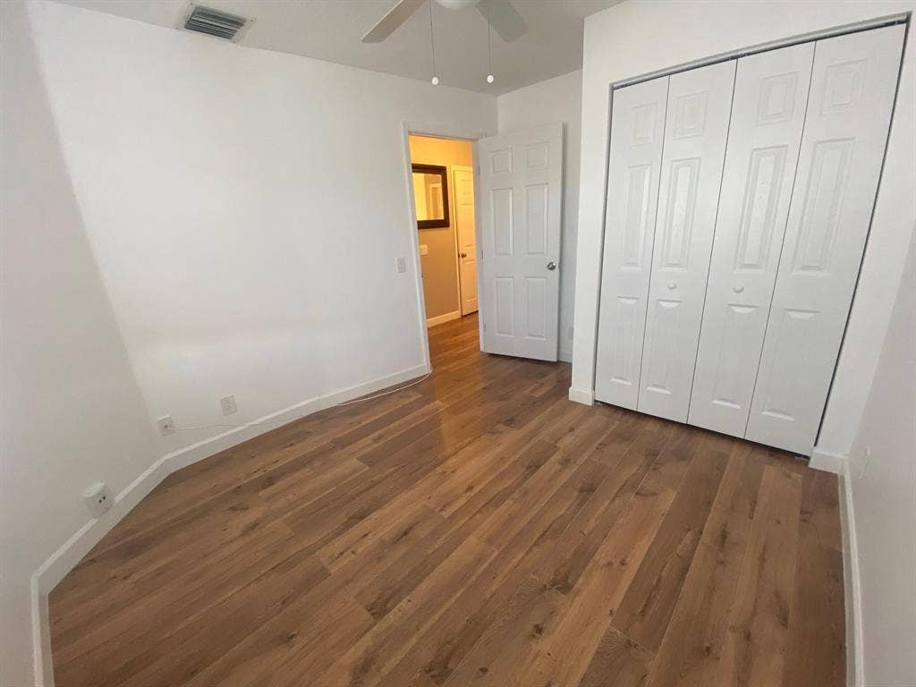 791 NW 42ND Place, Deerfield Beach, Deerfield Beach, FL 33064 2nd bedroom Wood-finish flooring with white baseboards, white walls, and a ceiling fan