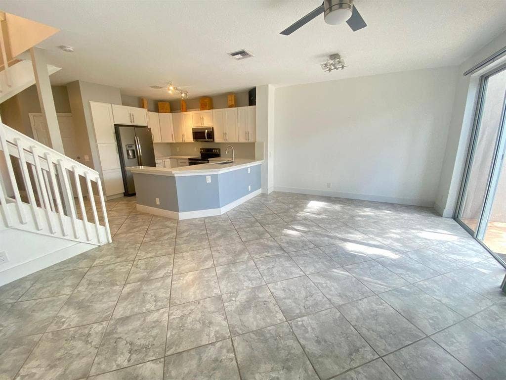 791 NW 42ND Place, Deerfield Beach, Deerfield Beach, FL 33064 Open-concept living space with large format tile flooring, a kitchen featuring white cabinetry and stainless steel appliances,