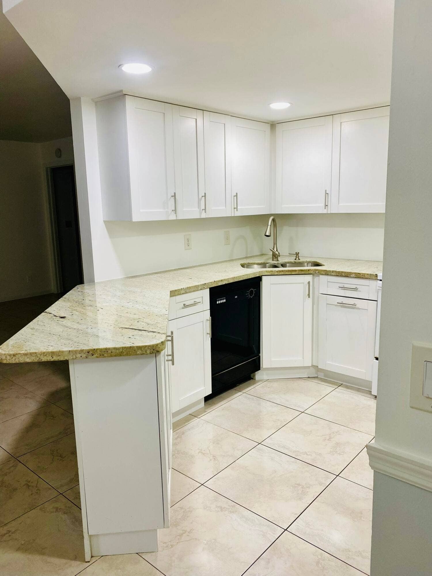 6520 Chasewood Drive, #C, Jupiter, Jupiter, FL 33458 Kitchen featuring white cabinetry, granite countertops, tile flooring, a built-in dishwasher, and a stainless steel sink with a high-arch faucet