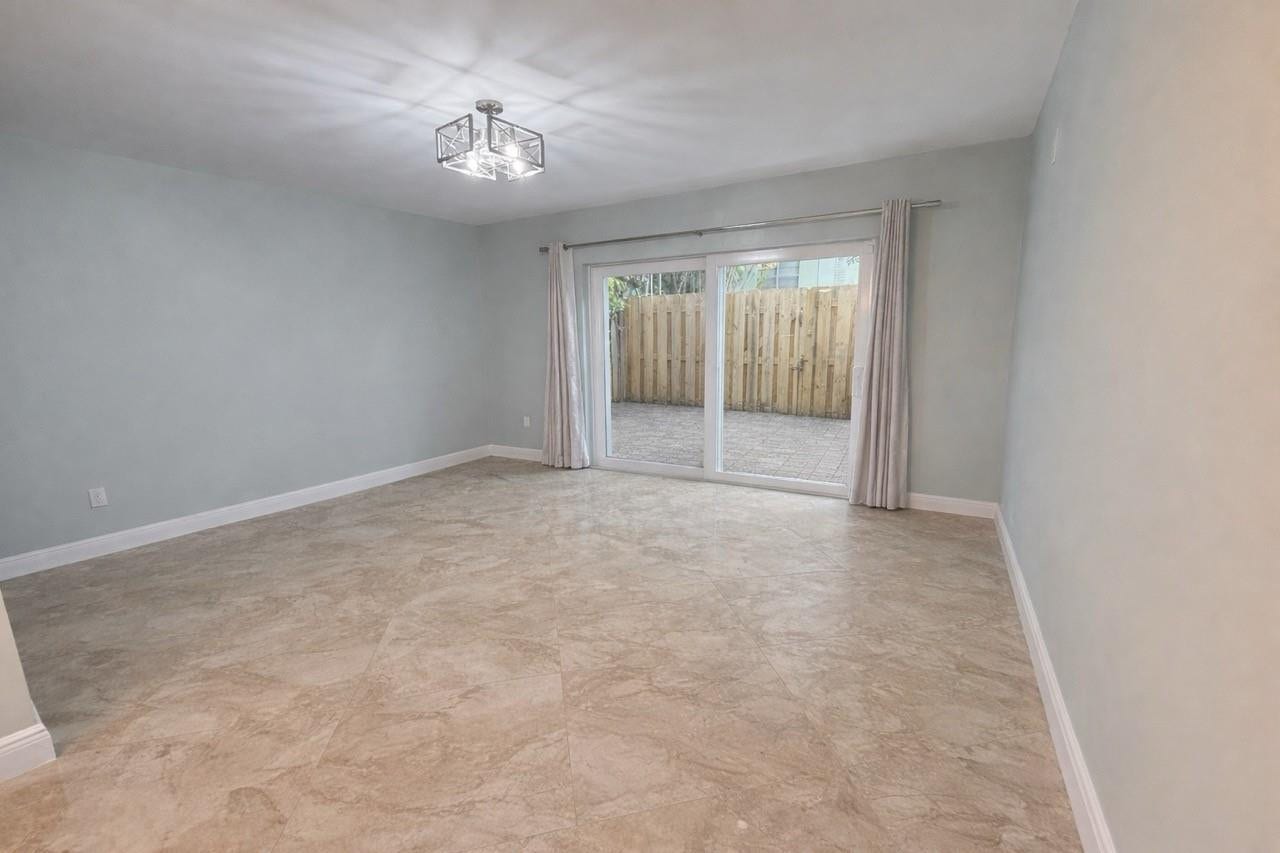 809 W Oakland Park Boulevard, #K4, Wilton Manors, FL 33311 Tiled flooring with a neutral finish, sliding glass doors, and a contemporary ceiling light fixture