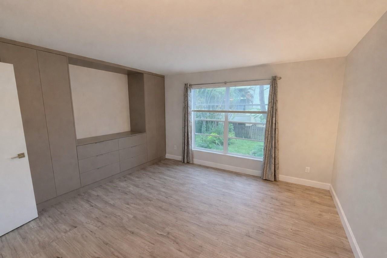 809 W Oakland Park Boulevard, #K4, Wilton Manors, FL 33311 Built-in cabinetry with integrated drawers, wood-finish flooring, and a large window