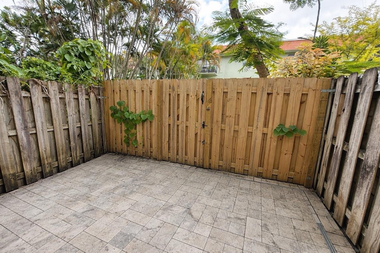 809 W Oakland Park Boulevard, #K4, Wilton Manors, FL 33311 Paved outdoor patio with a plank wood fence and privacy gate