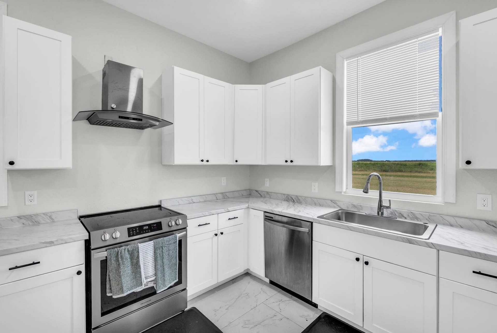 Kitchen with stainless range, dishwasher and window over the sink