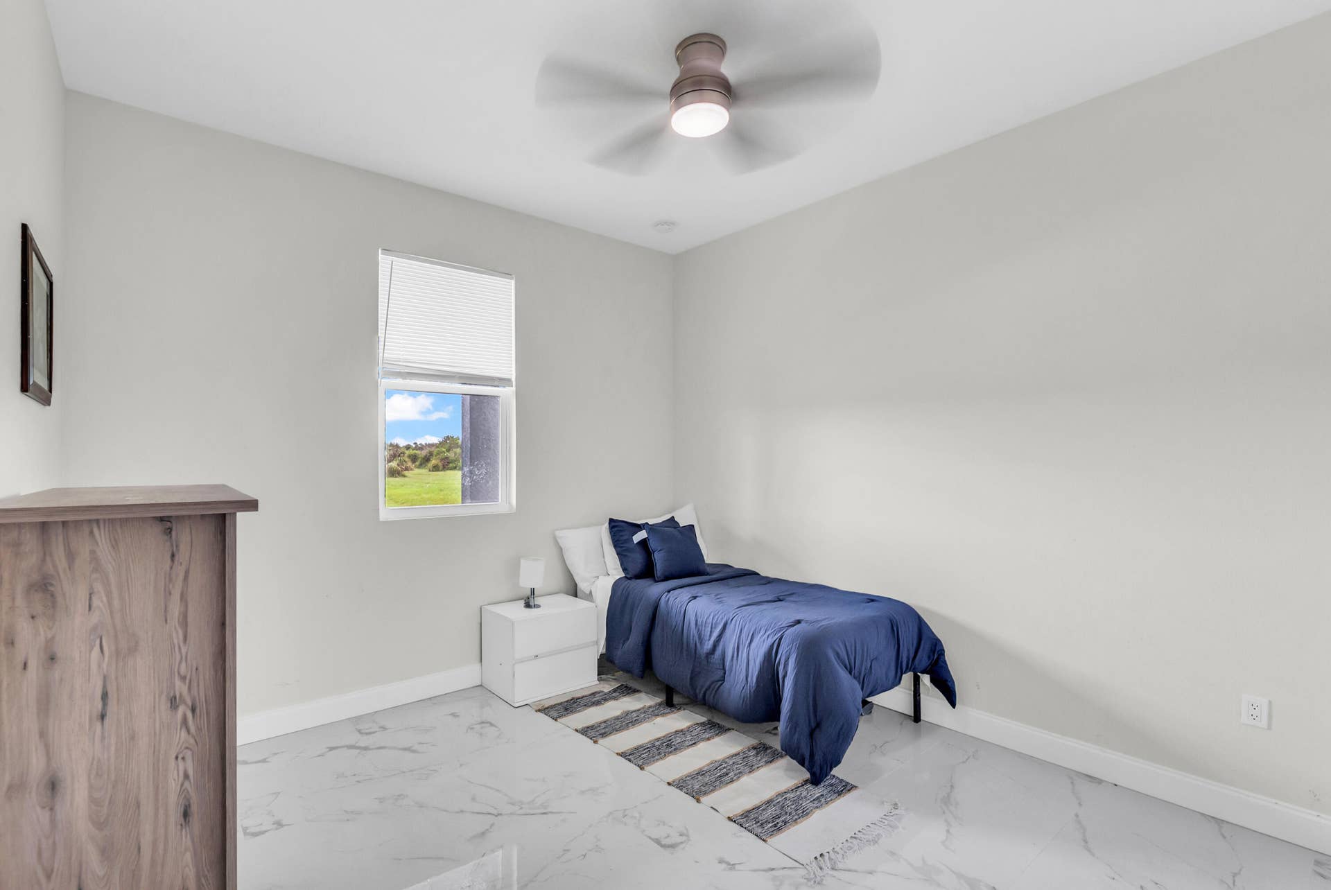 Guest bedroom with ceiling fan and natural light