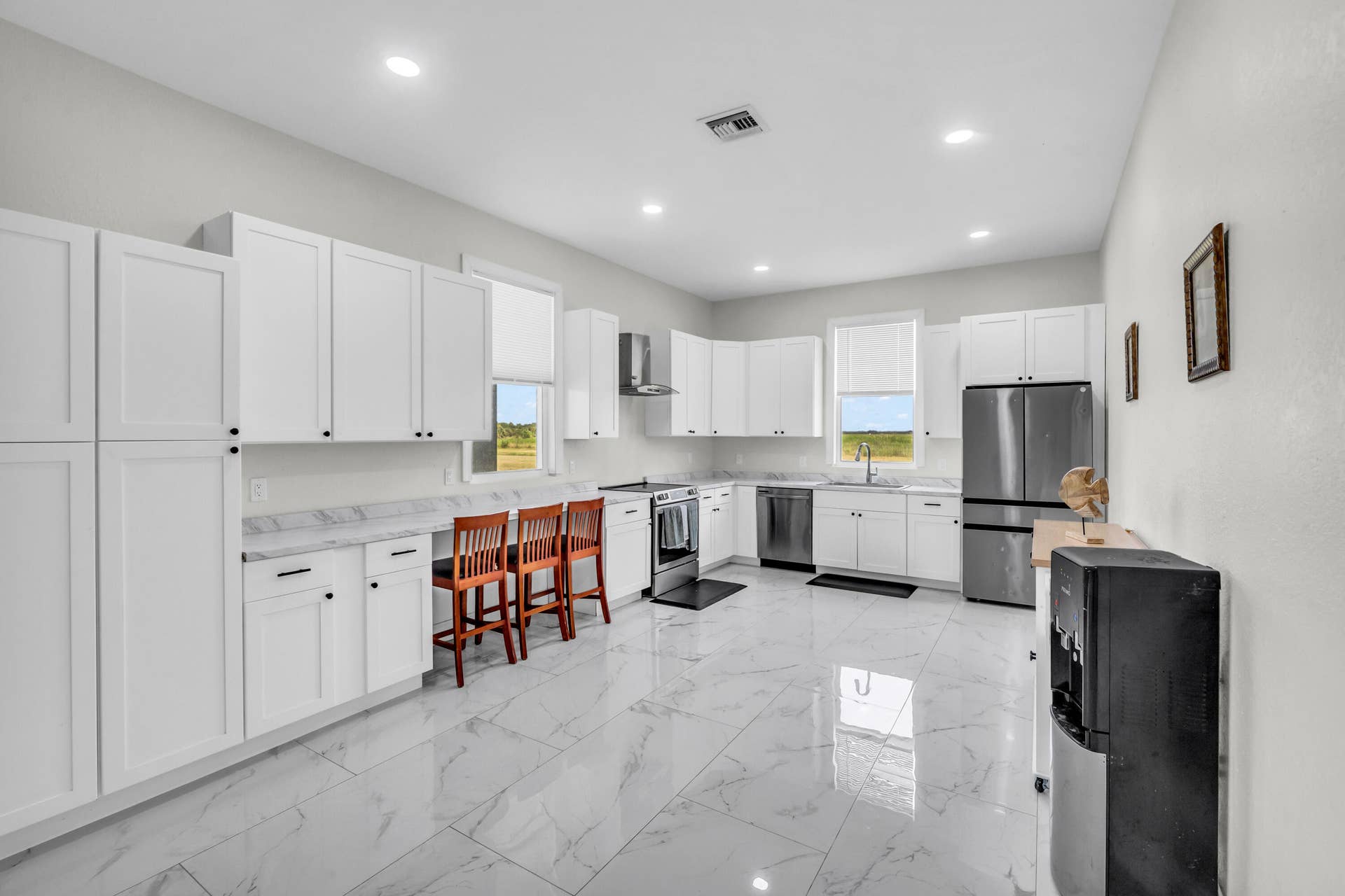 White kitchen with stainless appliances and breakfast-bar seating