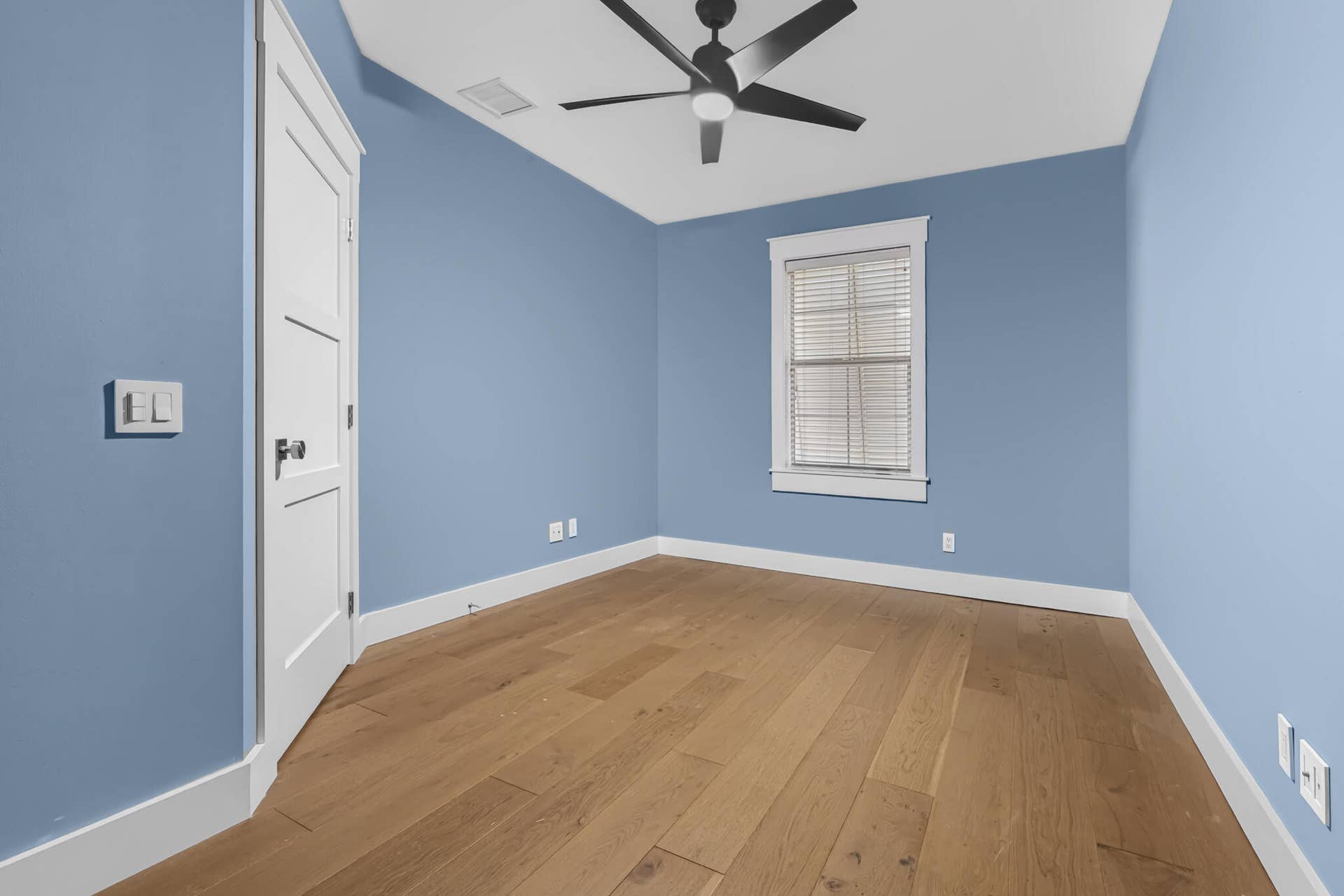 3207 E Community Drive E, Jupiter, FL 33458 Wood-finish flooring, sliding glass door, modern ceiling fan, and white trim throughout