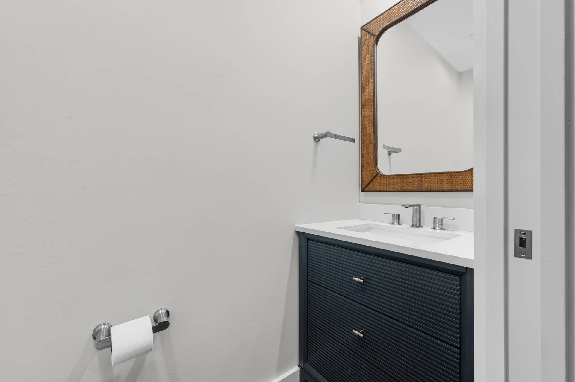 3207 E Community Drive E, Jupiter, FL 33458 Vanity with reeded paneling, white countertop, integrated sink, and polished chrome faucet