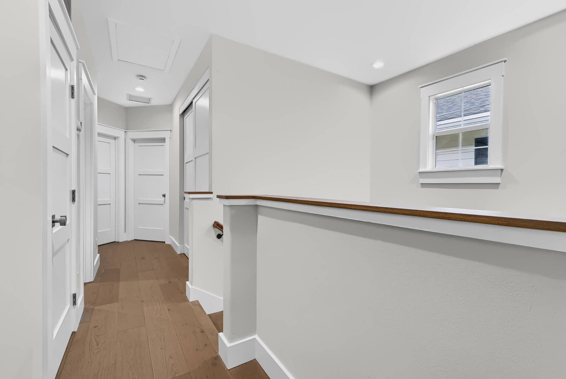 3207 E Community Drive E, Jupiter, FL 33458 Hallway featuring wood-finish flooring, white panel doors, and recessed lighting