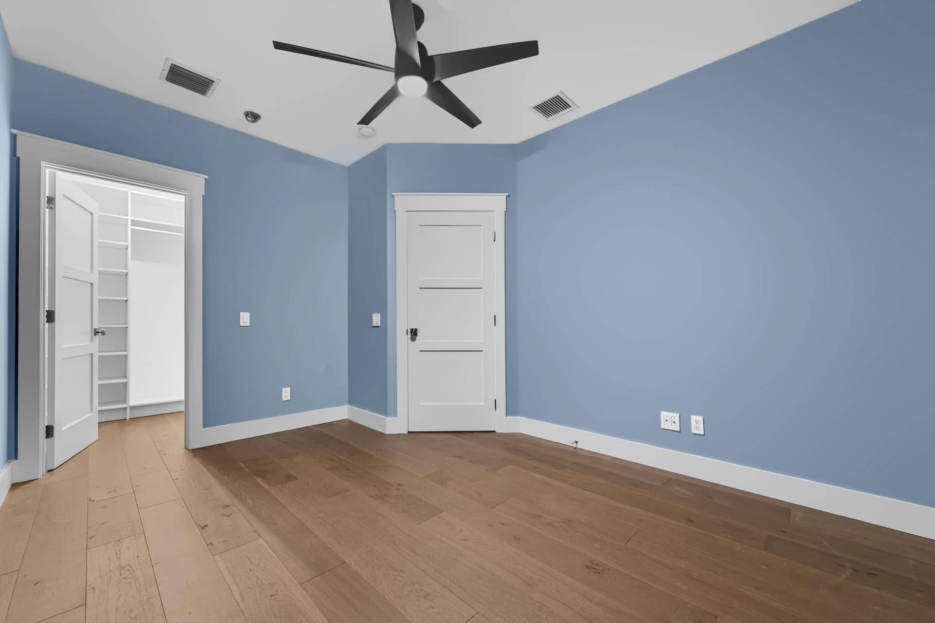 3207 E Community Drive E, Jupiter, FL 33458 Wood-finish flooring, ceiling fan, white trim, and a walk-in closet with built-in shelving