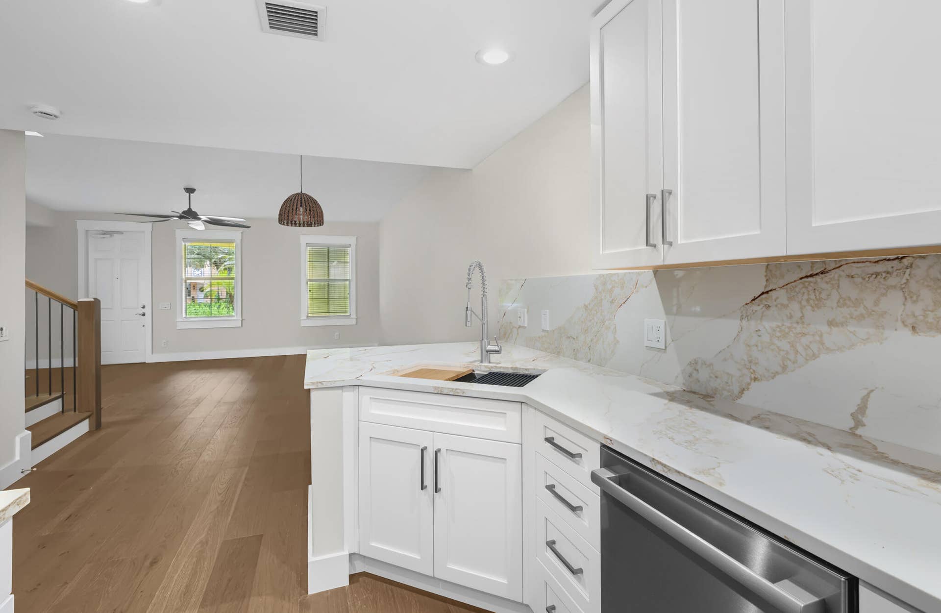 3207 E Community Drive E, Jupiter, FL 33458 White shaker cabinetry with dark hardware, stone countertops with matching backsplash, and stainless steel appliances