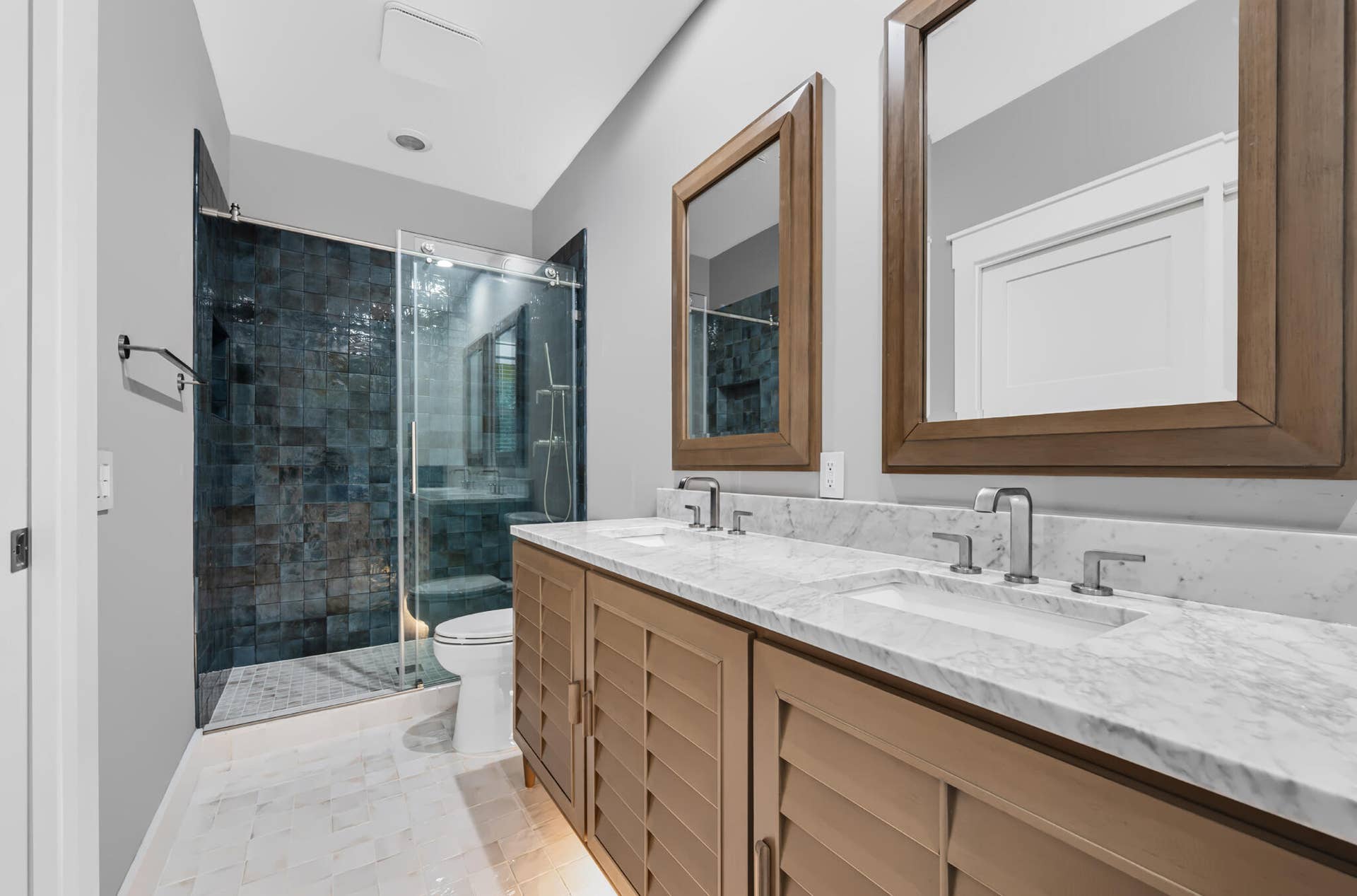 3207 E Community Drive E, Jupiter, FL 33458 Dual vanity with integrated sinks and polished chrome fixtures, set against a stone countertop