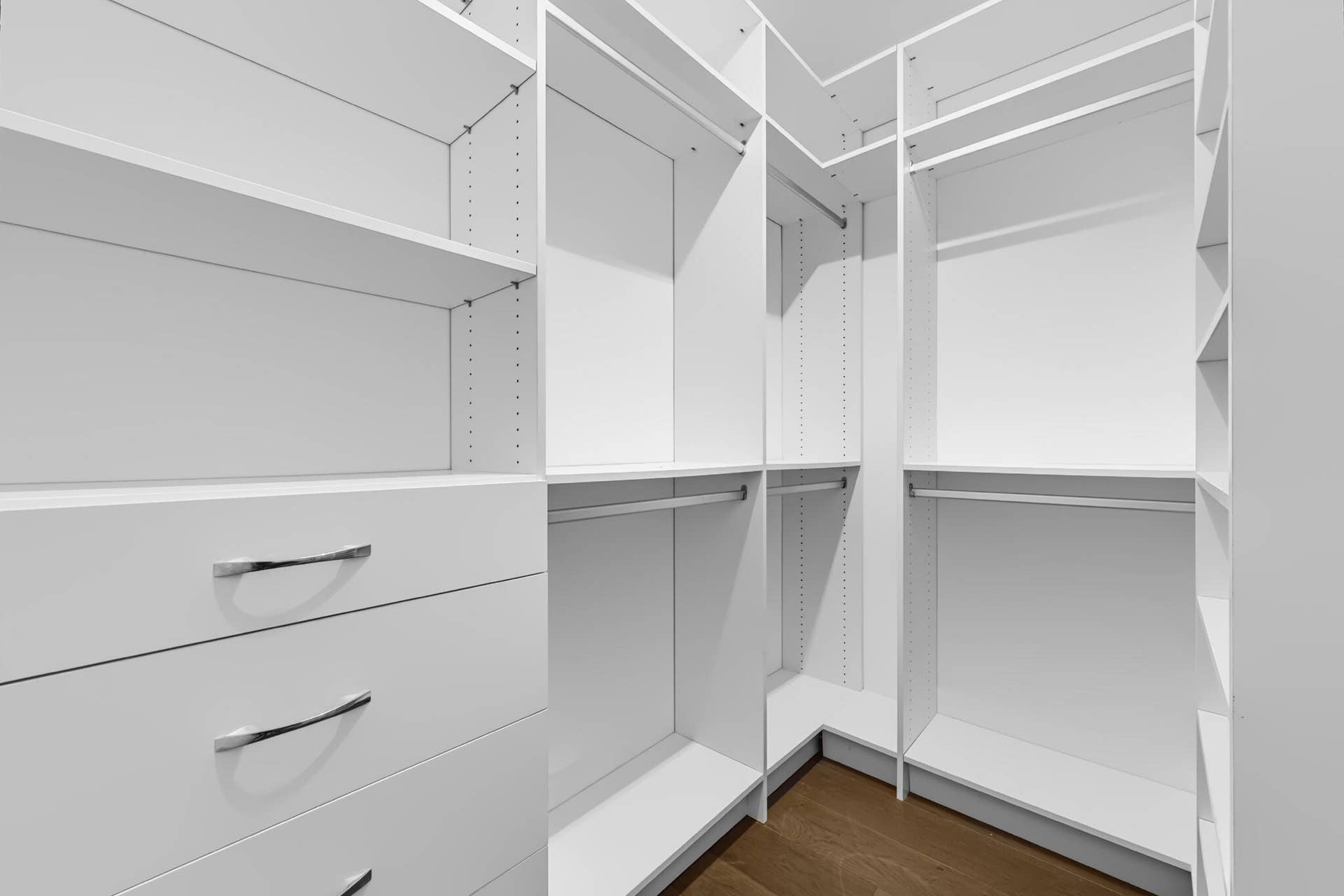 3207 E Community Drive E, Jupiter, FL 33458 Custom closet system featuring multiple shelves, drawers with chrome pulls, and hanging rods