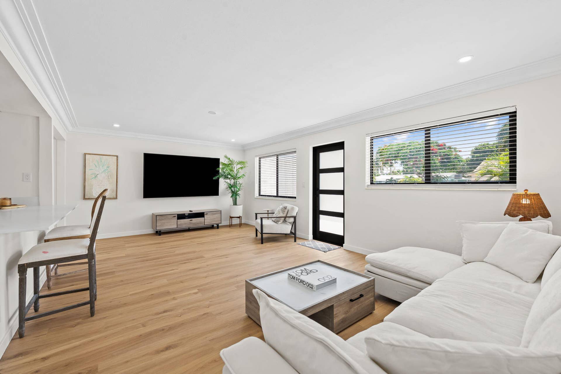 Expansive living area with light wood-finish flooring, recessed lighting, and crown molding