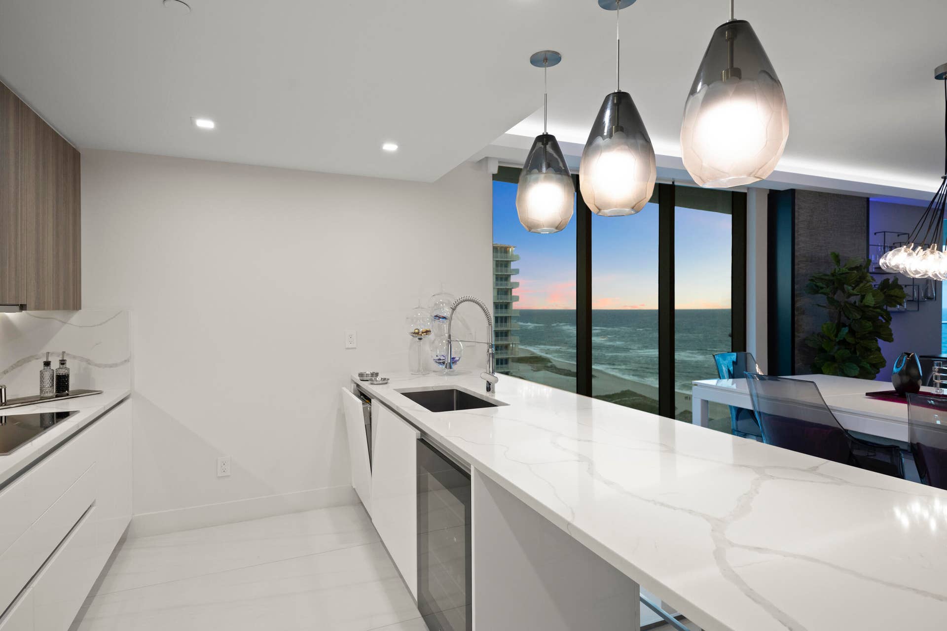730 N Ocean Boulevard, Pompano Beach, FL 33062 As the sun sets, custom lighting and illuminated accent walls glow in harmony with the soft, colorful evening light that fills the residence.