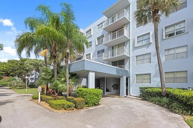 480 EXECUTIVE CENTER Drive, #2F, West Palm Beach, West Palm Beach, FL 33401 Multi-story building with a light blue exterior, featuring multiple balconies with white railings