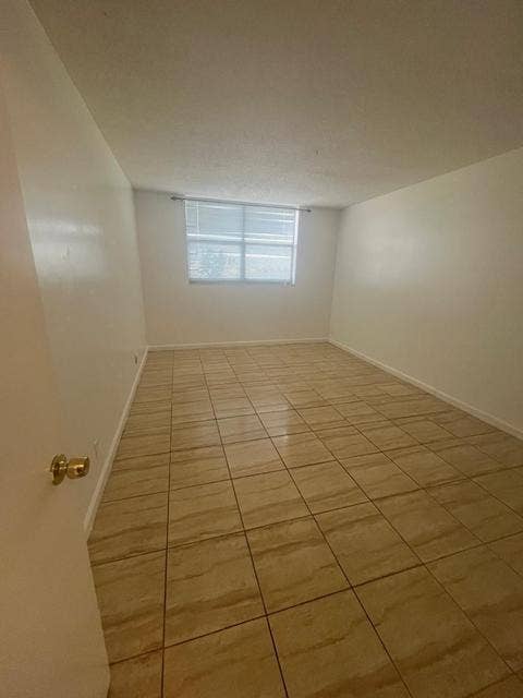 480 EXECUTIVE CENTER Drive, #2F, West Palm Beach, West Palm Beach, FL 33401 Light-toned ceramic tile flooring, neutral wall tones, and a window with horizontal blinds