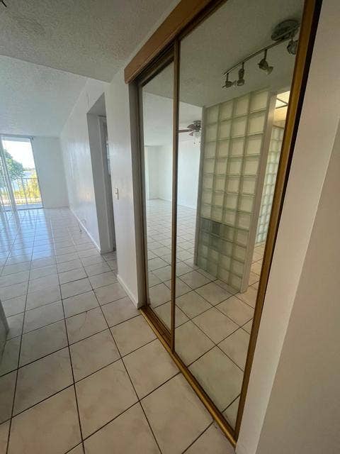 480 EXECUTIVE CENTER Drive, #2F, West Palm Beach, West Palm Beach, FL 33401 Mirrored sliding closet doors, ceiling-mounted track lighting, and a glass block wall feature