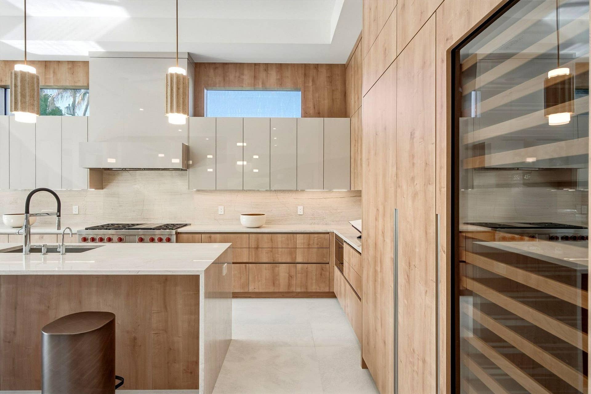 Modern kitchen featuring wood-finish cabinetry, light-toned countertops, and a built-in wine refrigerator